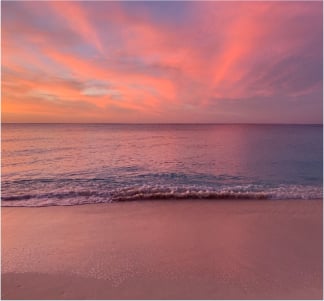 a sunset setting over the beach and ocean